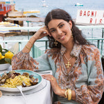 image shows model wearing pearl and gold gemstone pendant cross necklace on cord