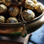 Pendant charm necklace on a bowl full of chocolates