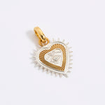 Gold and silver heart-shaped pendant on a light gray background