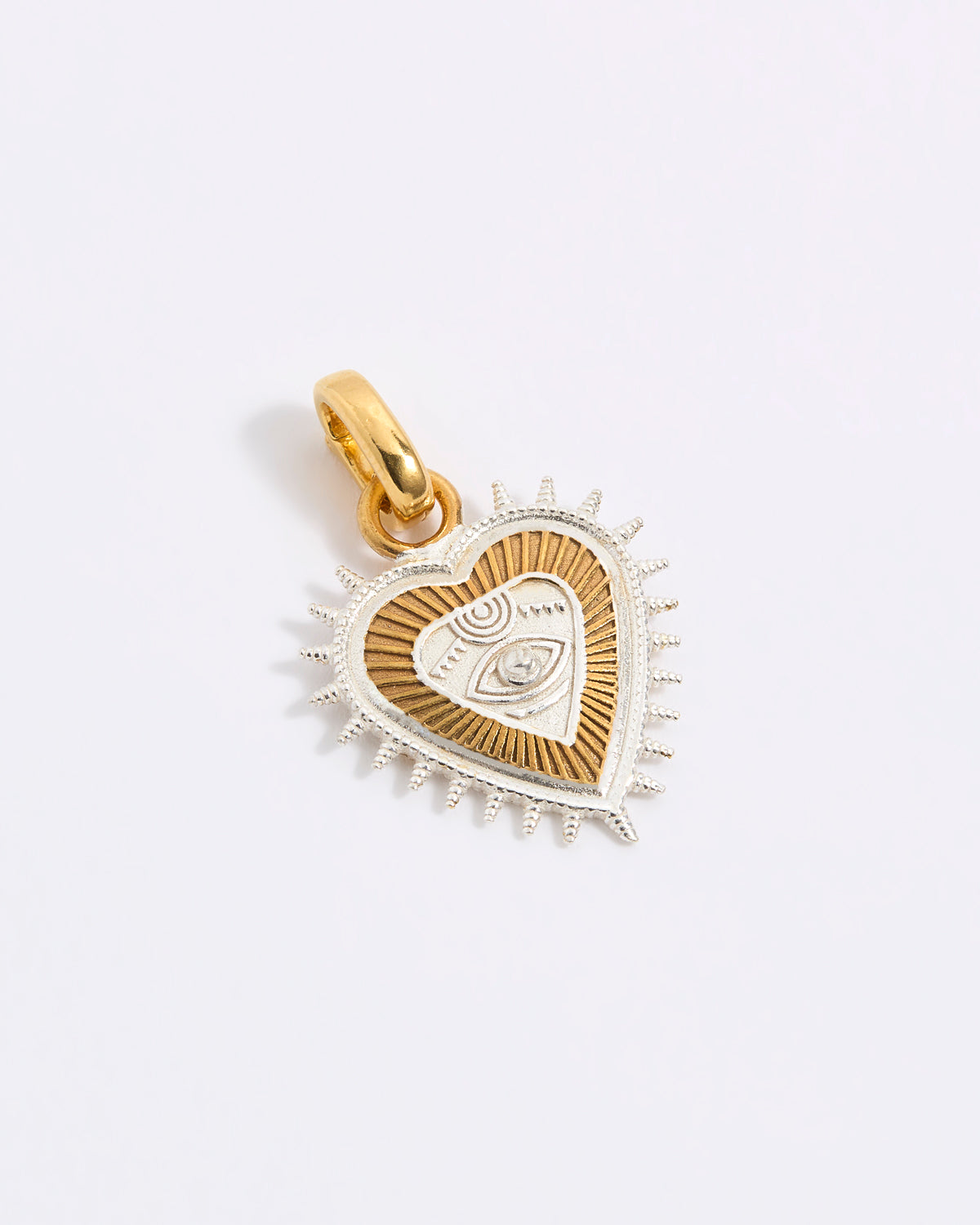 Gold and silver heart-shaped pendant on a light gray background