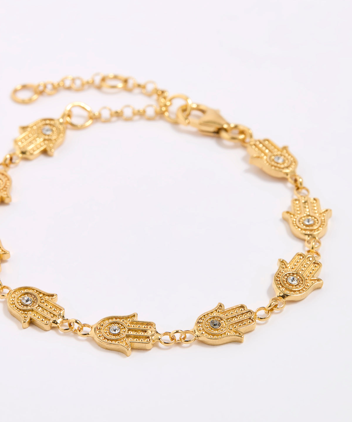 Gold bracelet with hamsa hand designs on a white background