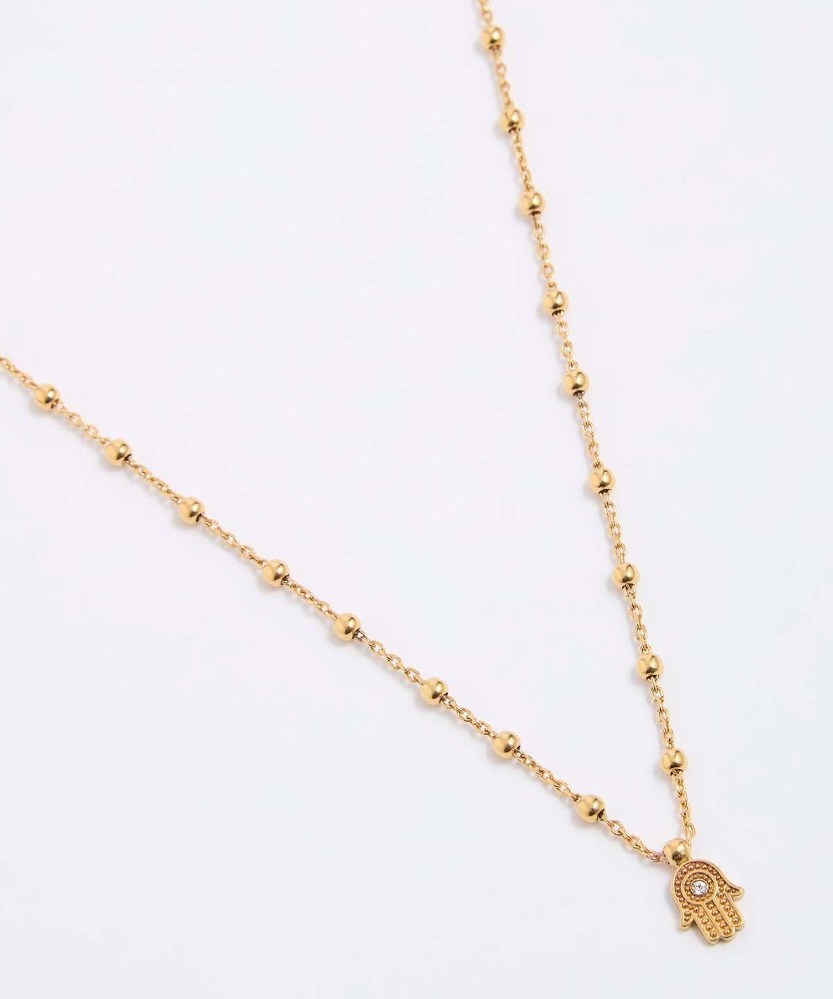 Gold coloured necklace with a hamsa hand pendant on a white background