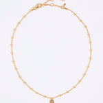 Gold coloured necklace with a hamsa hand pendant on a white background