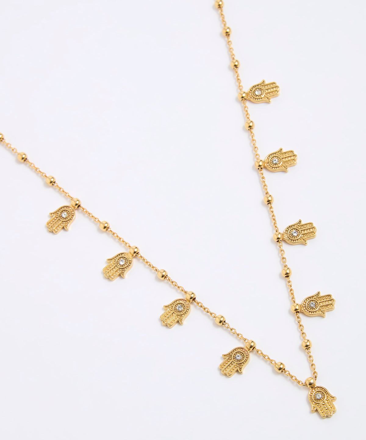 Gold necklace with hamsa hand charms on a white background