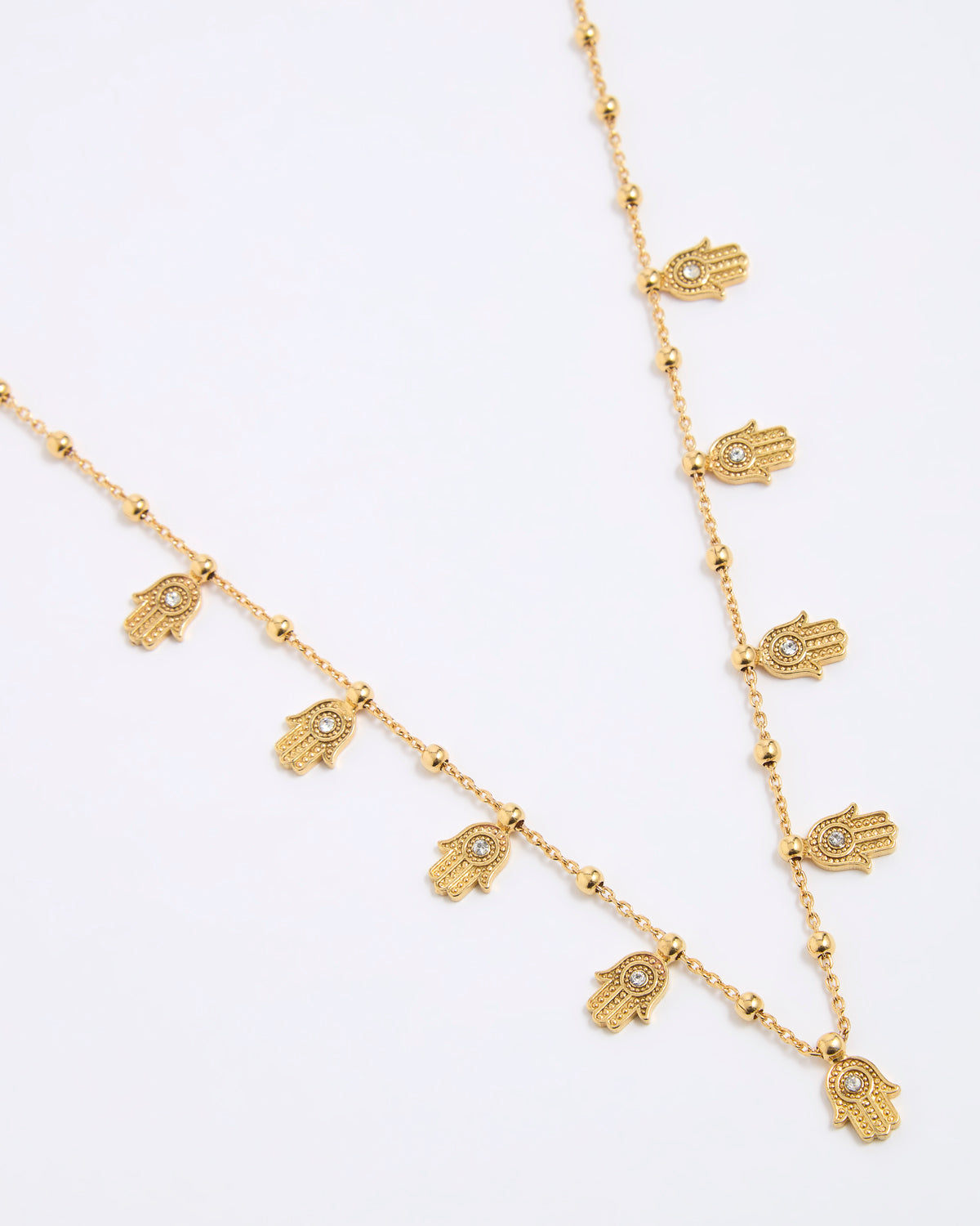 Gold necklace with hamsa hand charms on a white background