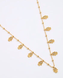Gold necklace with hamsa hand charms on a white background