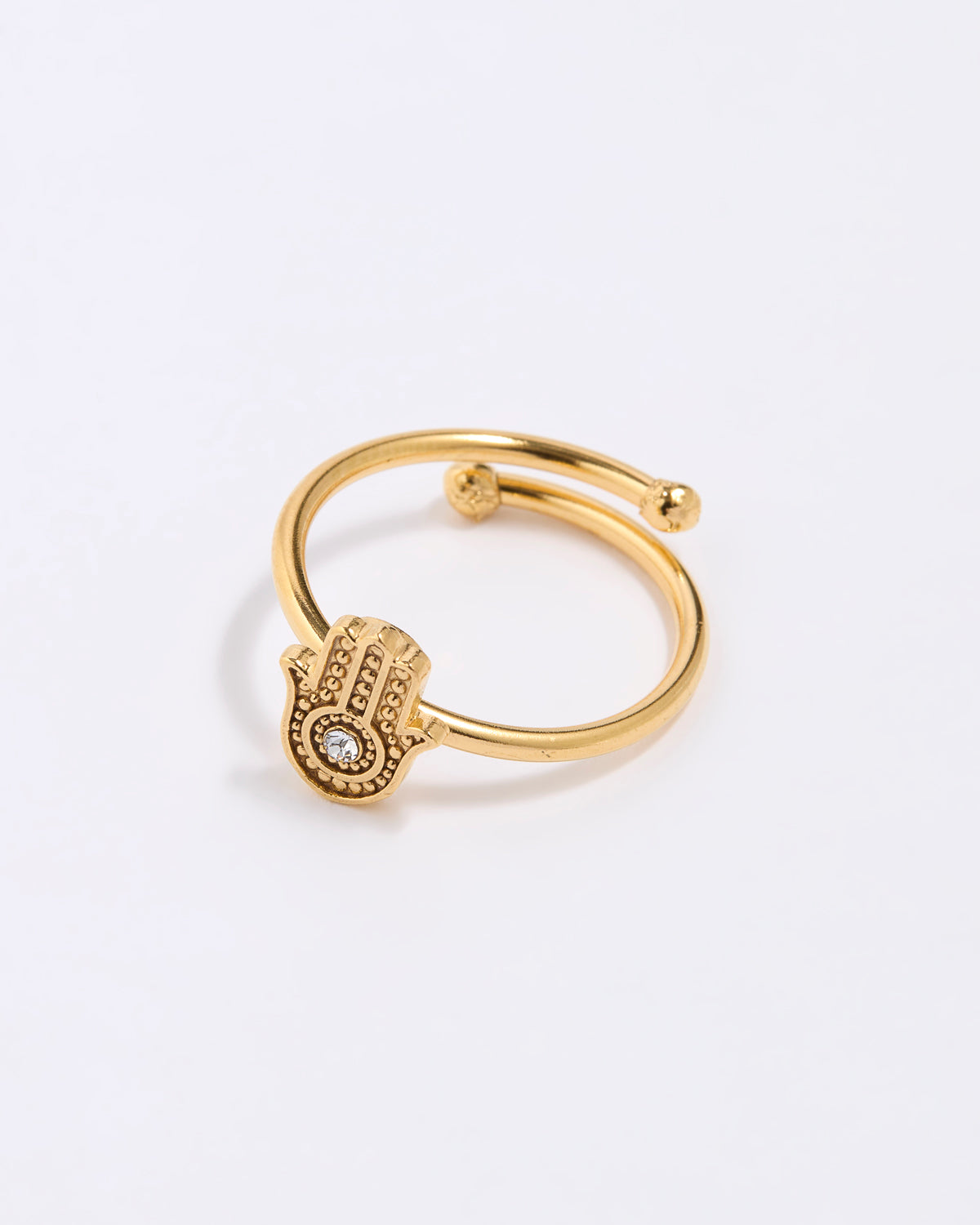 Gold coloured  ring with a hamsa hand design on a white background