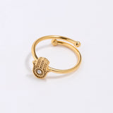 Gold coloured  ring with a hamsa hand design on a white background