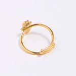 back shot of Gold coloured ring with a hamsa hand design on a white background