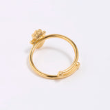 back shot of Gold coloured ring with a hamsa hand design on a white background