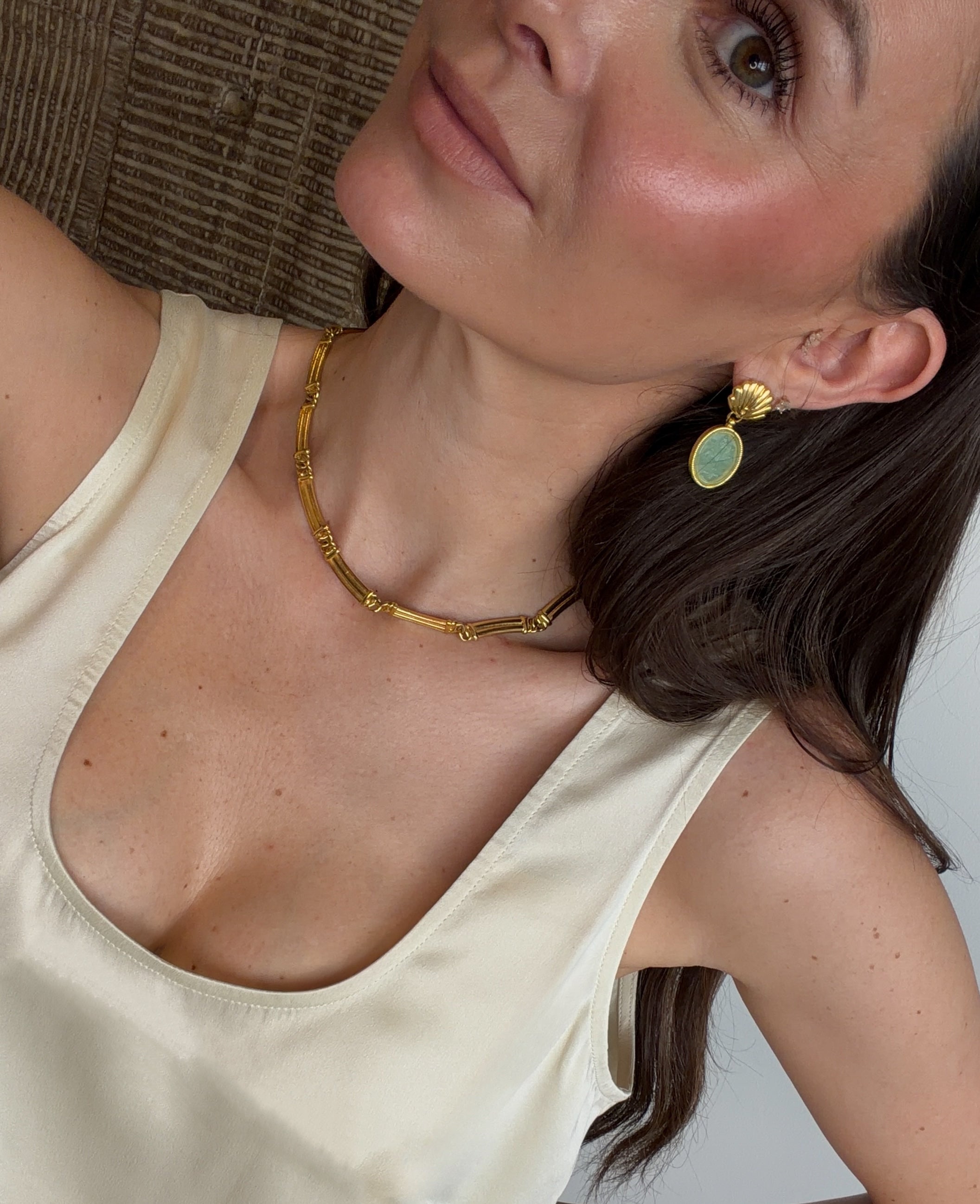 selfie shot of green earrings and gold coloured necklace