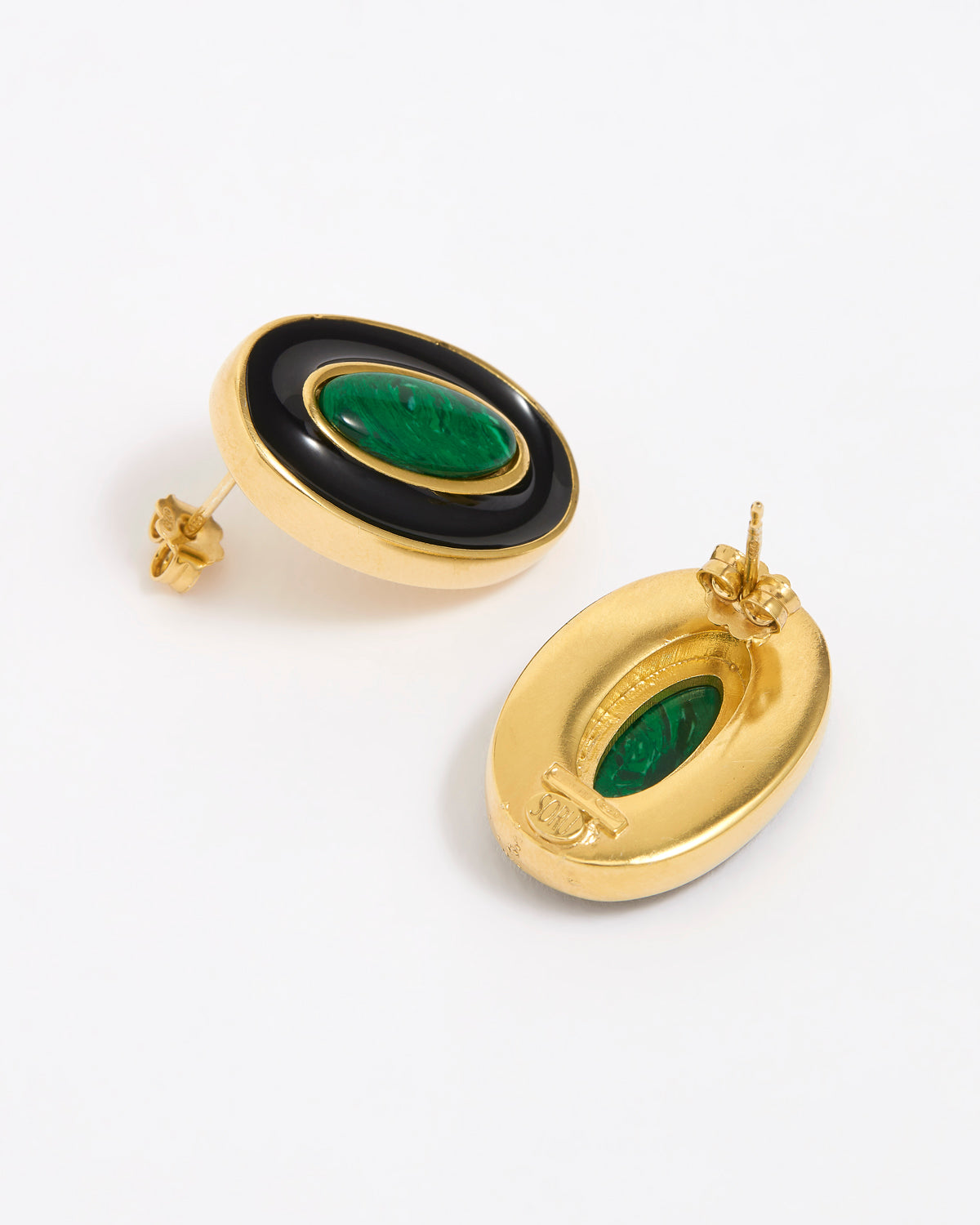 Close up of side and reverse product shot of gold earrings with green malachite stone and black enamel on a white background