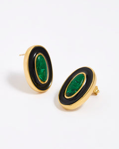 Close up image shot of gold earrings with green malachite stone and black enamel  on a white background