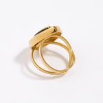 image shows back of Gold ring with a green malachite gemstone and black enamel surround on a white background