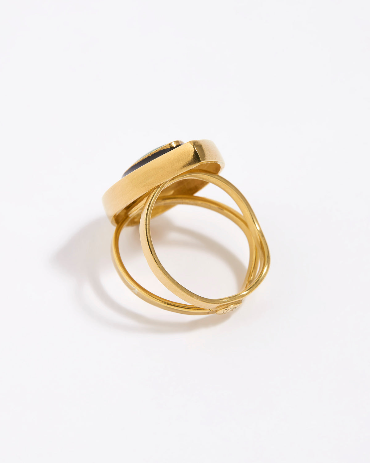 image shows back of Gold ring with a green malachite gemstone and black enamel surround on a white background