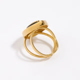 image shows back of Gold ring with a green malachite gemstone and black enamel surround on a white background