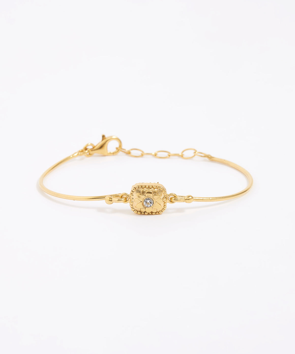 Gold bracelet with a decorative floral centre with a small crystal. set on a white background