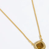 Gold necklace with a BROWN TIGERS EYE STONE SURROUNDED BY CRYSTALS ON A GOLD CHAIN on a white background