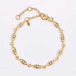 Gold bracelet with evil eye shape with turquoise stones on a light gray background