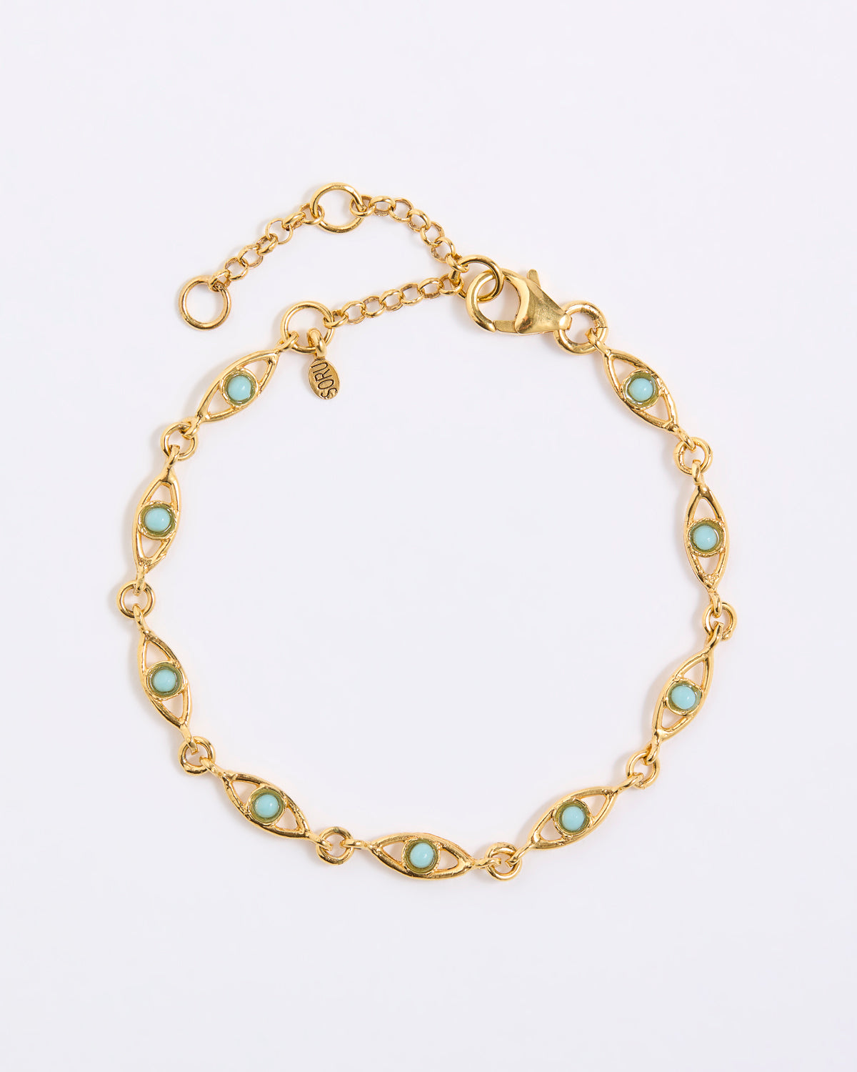 Gold bracelet with evil eye shape with turquoise stones on a light gray background