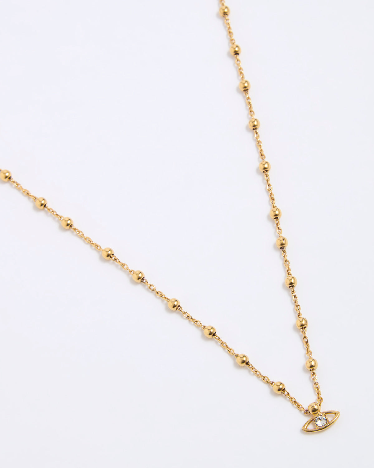 Gold coloured necklace with a small evil eye pendant on a white background