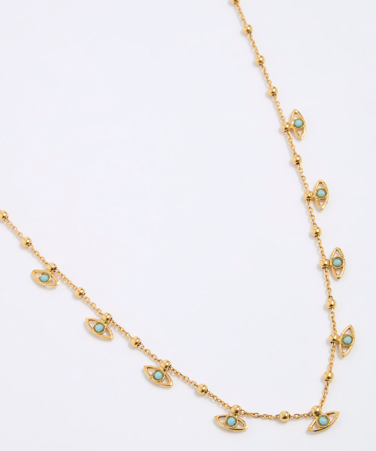 Gold coloured necklace with eye-shaped charms on a light gray background