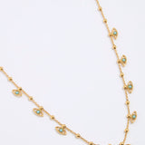 Gold coloured necklace with eye-shaped charms on a light gray background