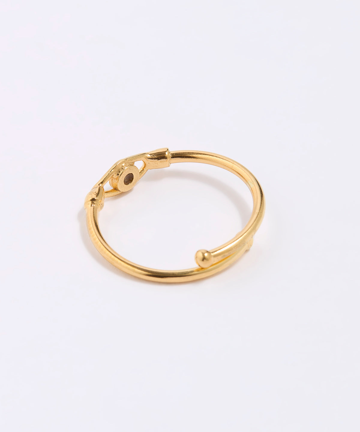 Gold coloured ring on a light gray background