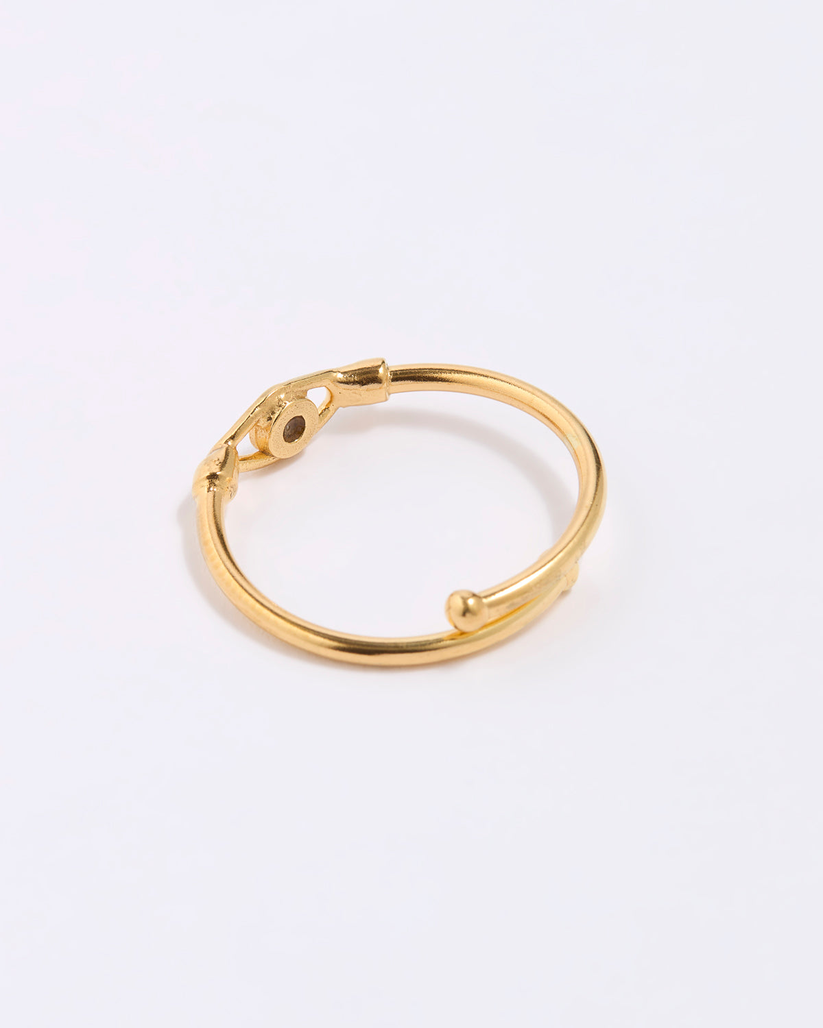 Gold coloured ring on a light gray background