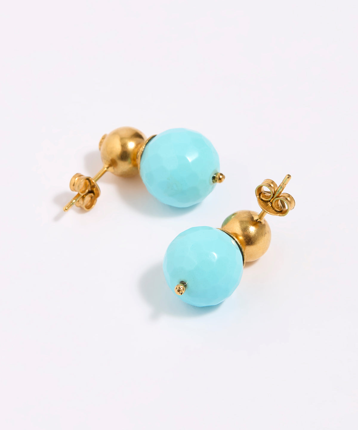 Pair of earrings with gold and turquoise beads on a white background