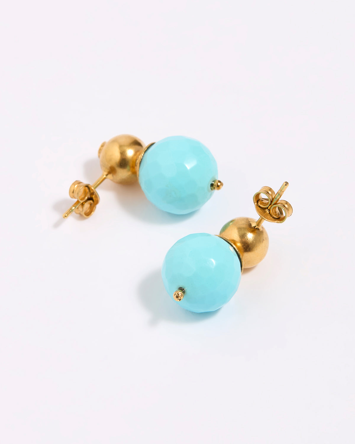 Pair of earrings with gold and turquoise beads on a white background