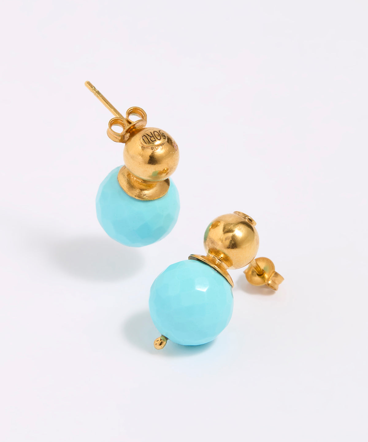 Pair of earrings with gold tops and turquoise beads on a white background