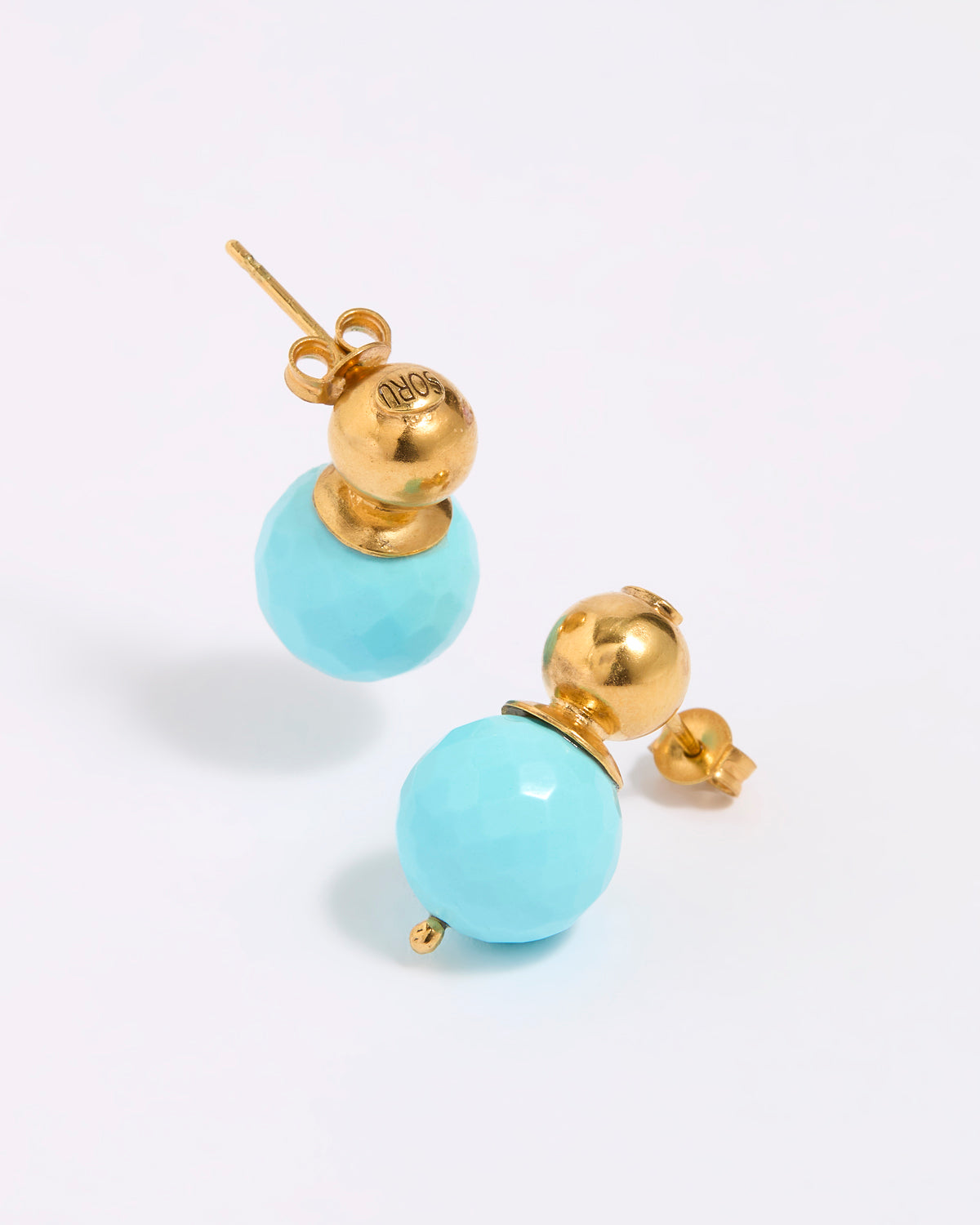 Pair of earrings with gold tops and turquoise beads on a white background