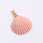 Pink shell pendant with gold coloured clasp on a light gray background