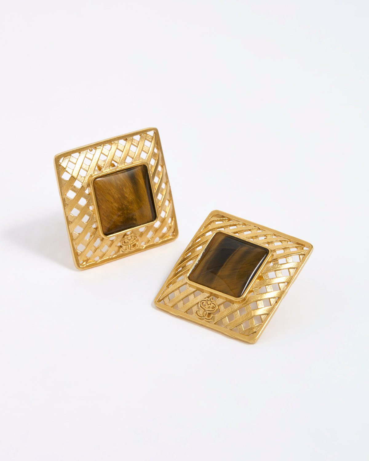Gold square earrings with a central tigers eye gemstone on a white background