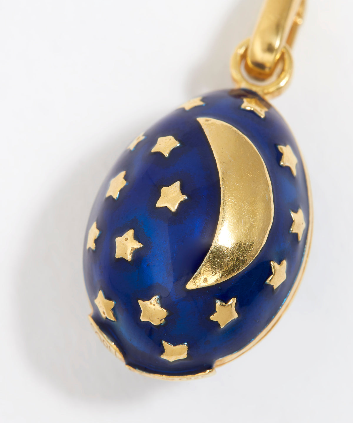 Midnight blue egg shaped charm pendant, with gold star sand crescent moon, on a white background