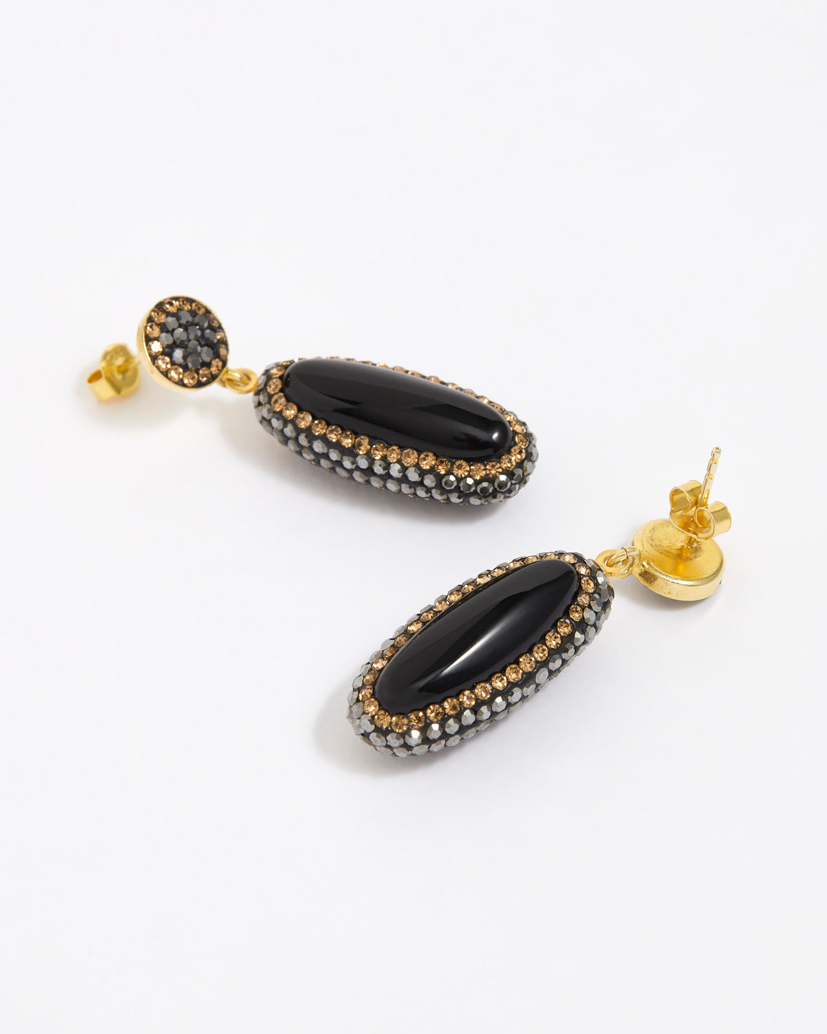 Pair of earrings with black stones and gold accents on a white background