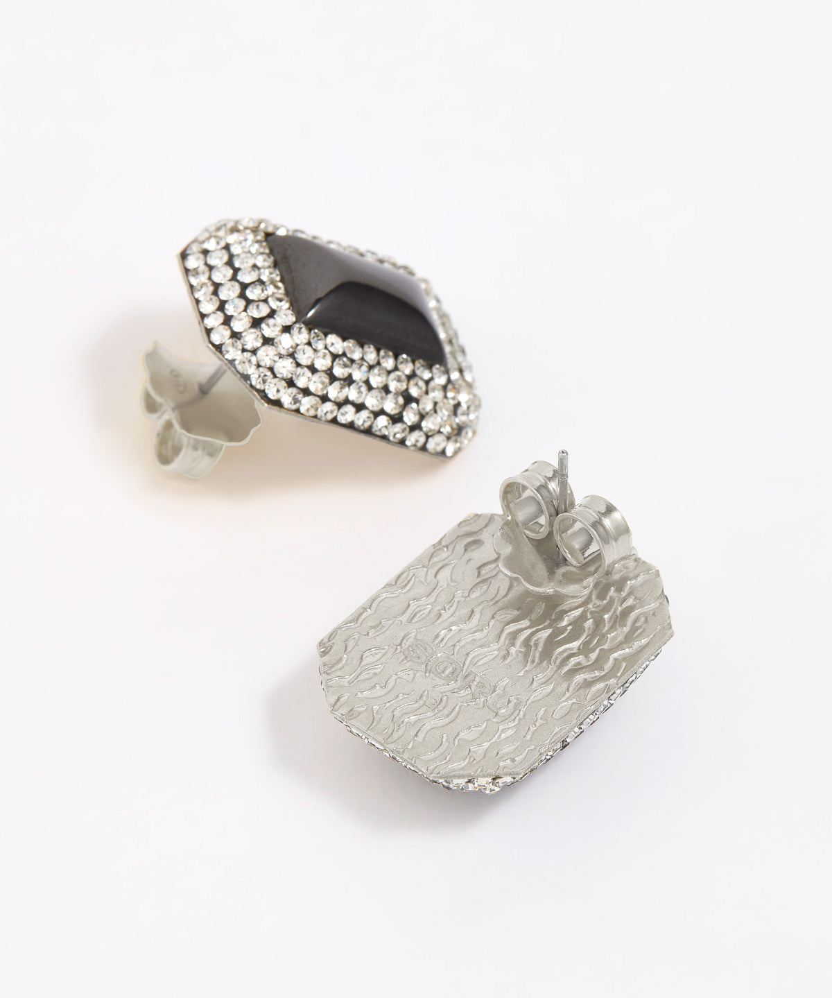 Square earrings with silver crystals surrounding a square onyx gemstone. Photo shows silver back of earrings. 