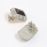 Square earrings with silver crystals surrounding a square onyx gemstone. Photo shows silver back of earrings. 