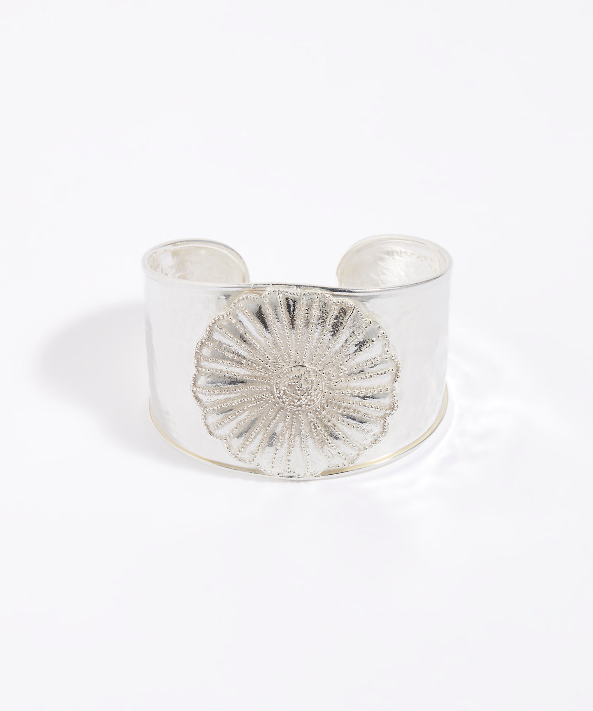 Silver cuff bracelet with a textured floral design on a white background