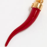 Close up Image of a red coral Cornicello horn shaped charm with gold top connector