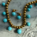 turquoise beaded necklace and earrings laid on marble 