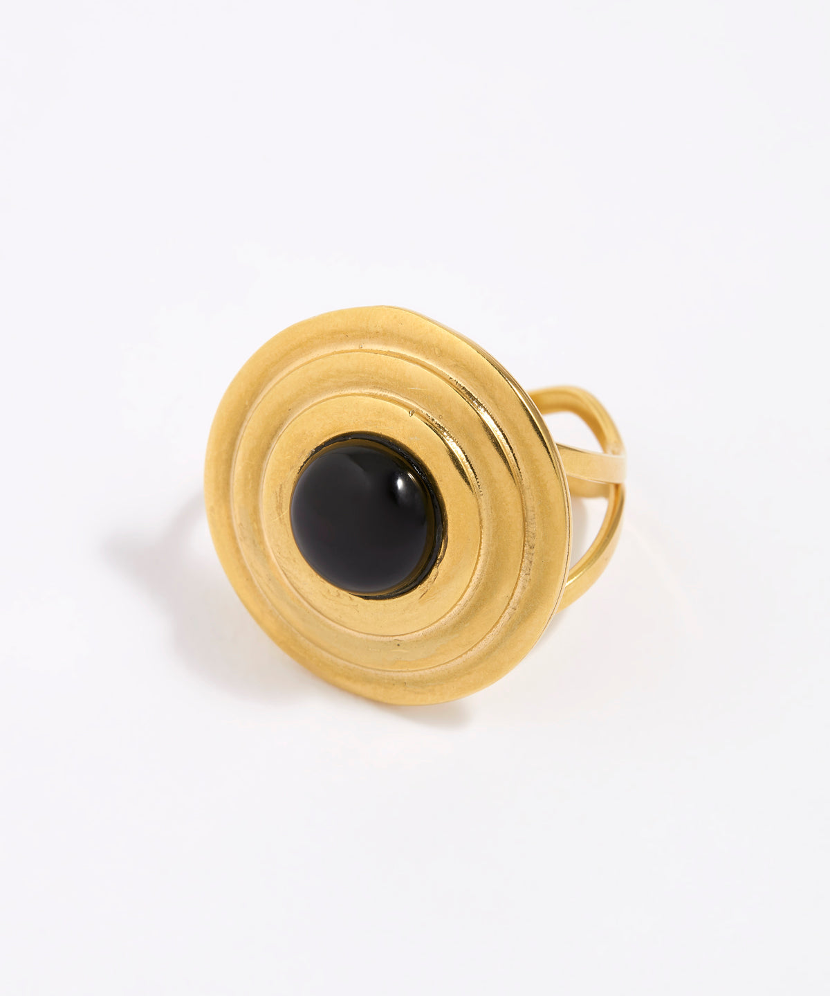 Gold ring with a round domed onyx gemstone set within circular gold frame,on a white background