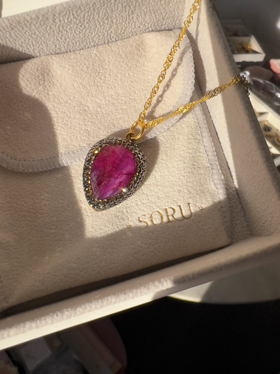ruby pendant necklace sparkling in natural sunlight in soru jewellery packaging 