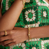 Close up model shot wearing bracelet with textured bar and pearls and also a chunky gold bracelet with a gold ring