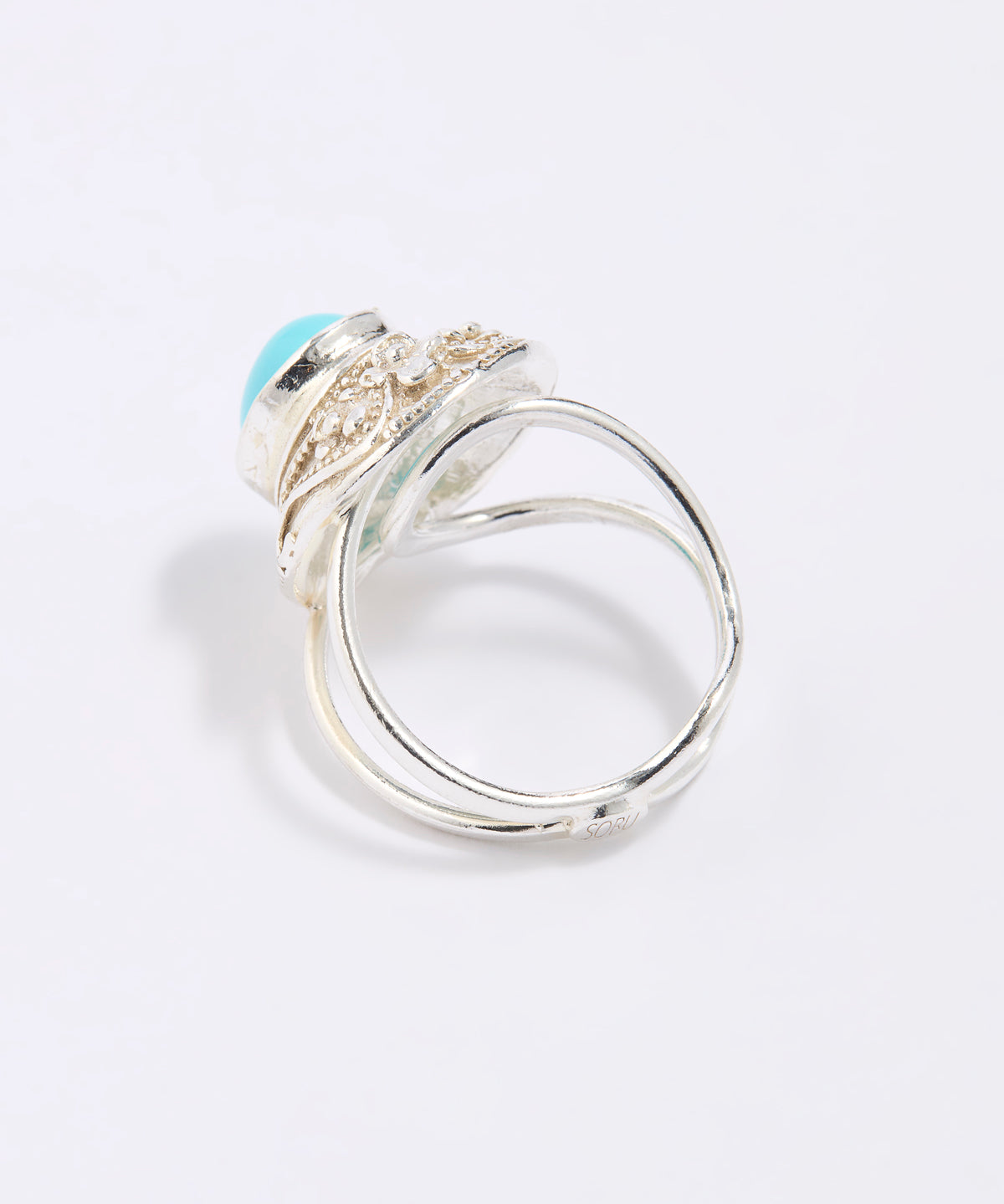 Silver ring with a blue gemstone on a light gray background