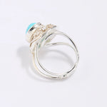 Silver ring with a blue gemstone on a light gray background