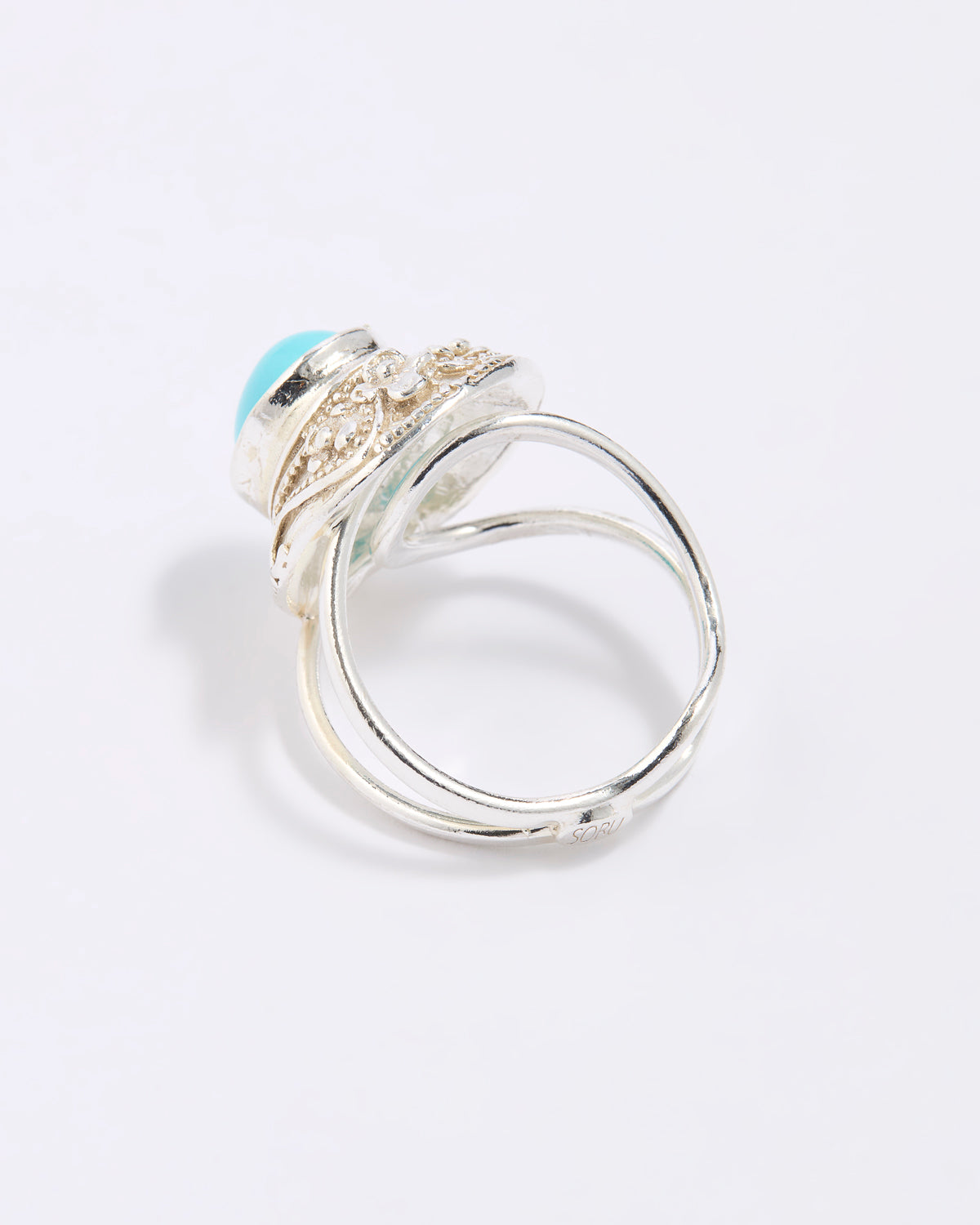 Silver ring with a blue gemstone on a light gray background