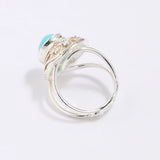 Silver ring with a blue gemstone on a light gray background