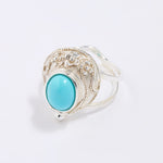 Silver ring with a turquoise stone on a white background